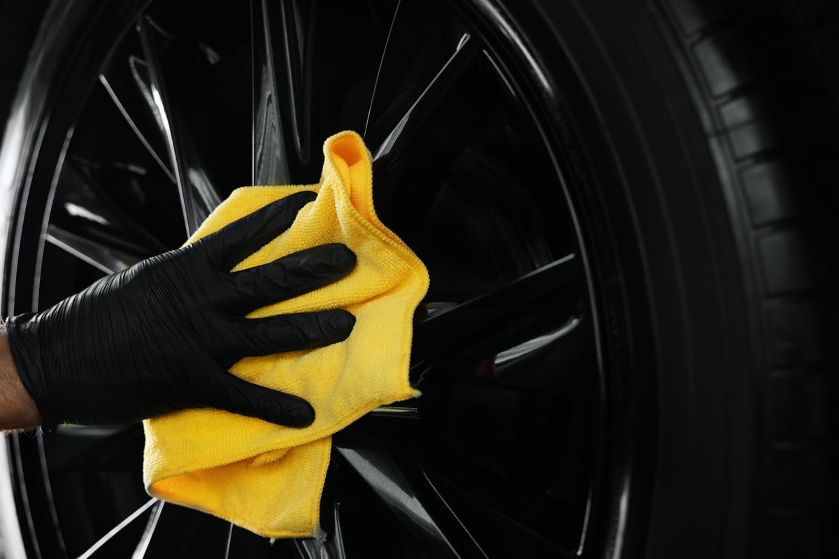 Professional car detailer polishing vehicle